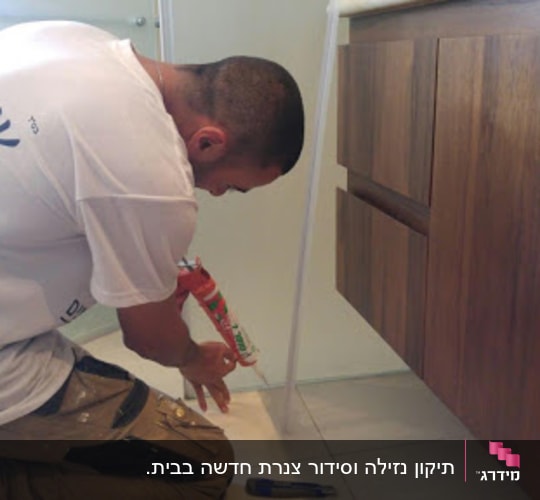אדם משתמש באקדח סיליקון ליד ארון עץ.